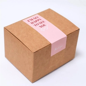 Autocollant de scellage rose rectangulaire avec texte 'Thank you' sur boîte en papier kraft
