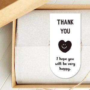 Close-up of white Thank You card with a black heart icon inside a kraft gift box