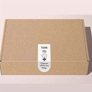Detail of kraft paper gift box with a white U-shaped Thank You seal sticker and floral icon