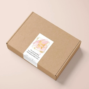 Close-up of pink watercolor Thank You sticker on a brown corrugated mailer box