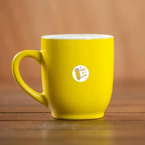 Detailed view of reward stickers on a mug featuring cartoon pencil and Keep It Up text
