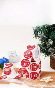 Close-up of circular Christmas stickers featuring snowman and deer on a wood tray