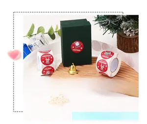 Detail view of round red Christmas stickers with Santa and reindeer on wooden tray