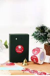 Close-up of round cartoon snowman Christmas gift stickers on a wooden tray