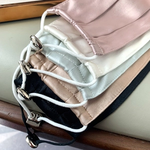 Detail of adjustable elastic ear loops and metal sliders on colorful silk face masks