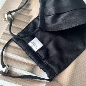 Detailed close-up of 100% mulberry silk face mask showing smooth texture and metal buckles
