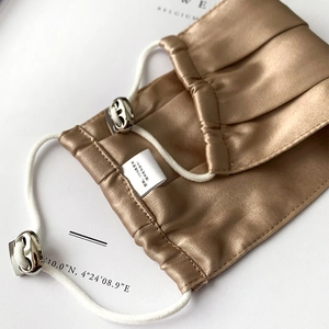 Detail of 100% pure mulberry silk face mask in champagne gold with adjustable metal buckle
