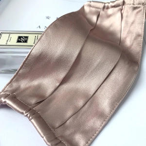 Macro detail of breathable champagne silk face mask with elegant satin texture
