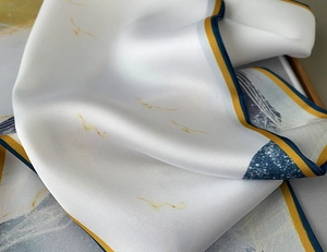 Dettaglio del tessuto del foulard in seta con trama liscia e motivo a uccelli