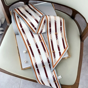 Dettaglio di un foulard twilly elegante su scatola regalo con etichetta in poliestere