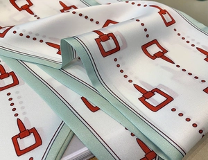 Dettaglio di sciarpa in seta twill con motivi equestri e trama satinata liscia