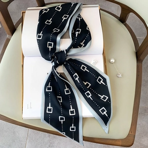 Elegante foulard stretto in seta con motivo a morsetto annodato su rivista