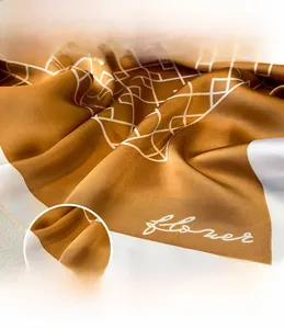 Vue macro de l'écharpe en soie montrant la couture fine et le motif géométrique