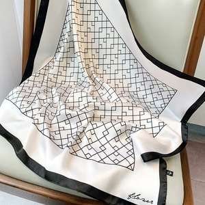 Vue détaillée d'un foulard carré en satin soyeux avec motif de grille géométrique noir et blanc