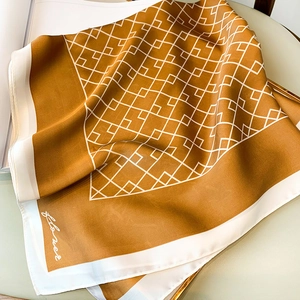 Détail d'un foulard en satin soyeux avec motifs géométriques et tons terre de caramel