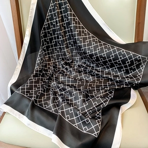 Détail d'un foulard en soie à motif géométrique montrant une texture et un drapé haut de gamme