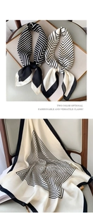 Detailed close-up of striped silk scarves in black and white geometric patterns