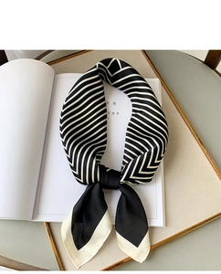 Detailed close-up of striped silk satin square scarf displayed on a luxury magazine tray