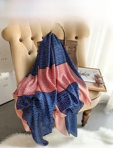Detail of elegant navy and pink silk-like scarf with geometric print on a chair