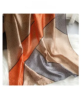 Detailed view of silk-texture scarf showing delicate hem stitching and geometric patterns
