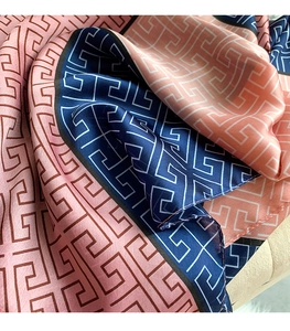 Detail of pink and navy silk scarf showing soft drape and classic Greek key pattern