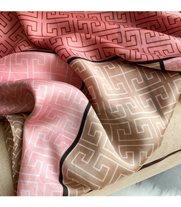 Detailed view of silk-like scarf featuring soft pink beige tones and Greek key patterns