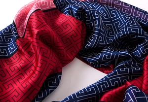 Detail of silk scarf showing retro geometric Greek key pattern and smooth texture