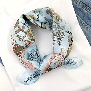 Light blue vintage silk scarf with bird and floral print tied on white t-shirt collar