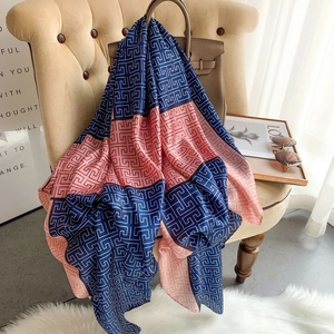 Elegant navy blue and pink silk shawl with geometric Greek Key patterns on a chair