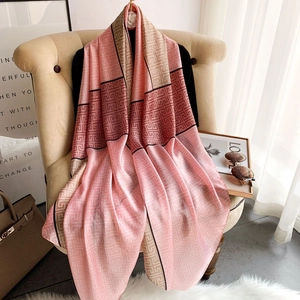 Elegant pink and beige geometric silk scarf draped over a chair for a chic summer look