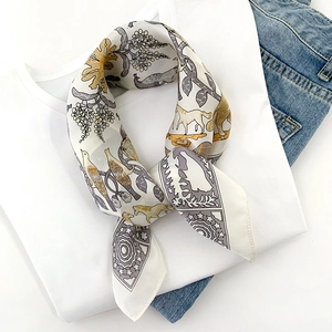 Detailed pattern of vintage silk scarf with horse and flower motifs on a white T-shirt
