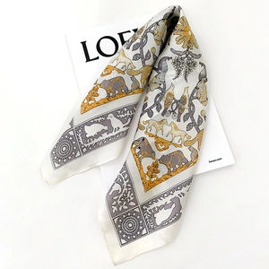 Detailed view of luxury silk scarf with vintage bird and floral prints on ivory fabric
