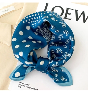 Détail du foulard en soie avec motif paisley et pois sur une chemise beige