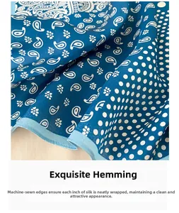 Gros plan des bords roulés à la machine d'un foulard en soie avec motif paisley bleu