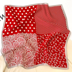 Détail d'un foulard en soie rouge et blanc avec motifs mélangés paisley et pois