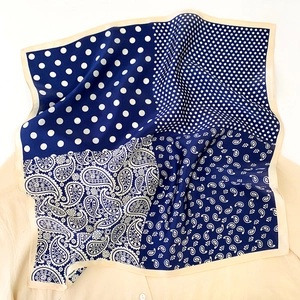 Détail d'un carré de soie avec motifs cachemire et pois sur tissu bleu marine