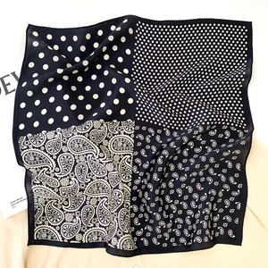Détail d'un foulard en soie avec motif patchwork paisley et pois noir et blanc