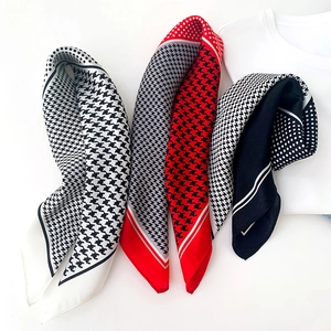 Gros plan de foulards carrés en soie avec motifs pied-de-poule et textures à pois
