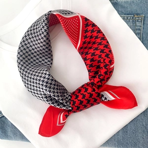 Détail d'un foulard en soie à carreaux rouge et noir avec motifs géométriques