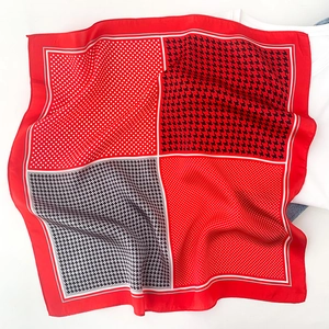 Détail d'un foulard en soie rouge à pois et motif pied-de-poule sur des vêtements