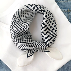 Détail d'un foulard en soie avec motif pied-de-poule noir et blanc et pois élégants