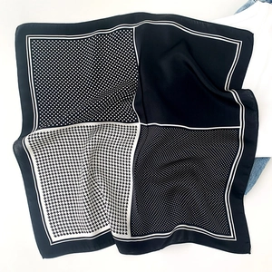 Détail d'un foulard en soie montrant le patchwork de pois noirs et blancs et pied-de-poule