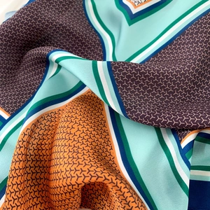 Macro shot of silk scarf showing geometric Y-pattern, colorful splicing and smooth texture