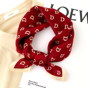 Macro shot of silk neck scarf in burgundy with white D patterns and contrast hem