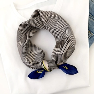 Foulard en soie pied-de-poule beige et noir avec bordure bleue sur un t-shirt blanc