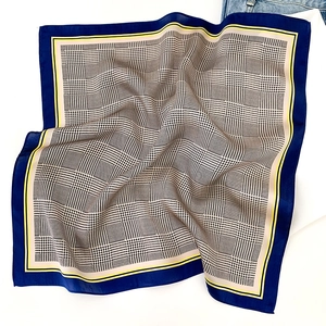 Détail d'un foulard en soie avec motif pied-de-poule classique et bordure bleu jaune