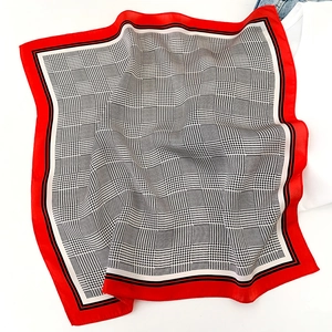Gros plan d'un foulard en soie avec motif pied-de-poule classique et bordure rouge vif