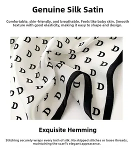 Close-up of silk scarf featuring black D-letter print and hand-rolled edges