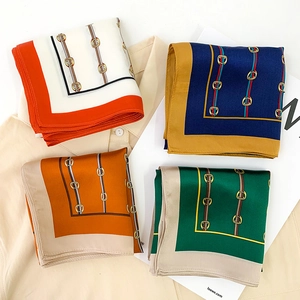 Macro shot of silk square scarves featuring horsebit patterns in four vibrant colors