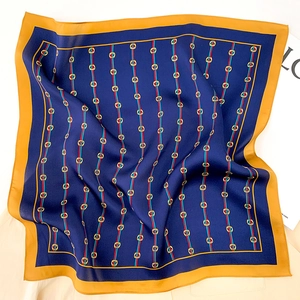 Detail of silk scarf with navy blue base, yellow border and golden horsebit pattern